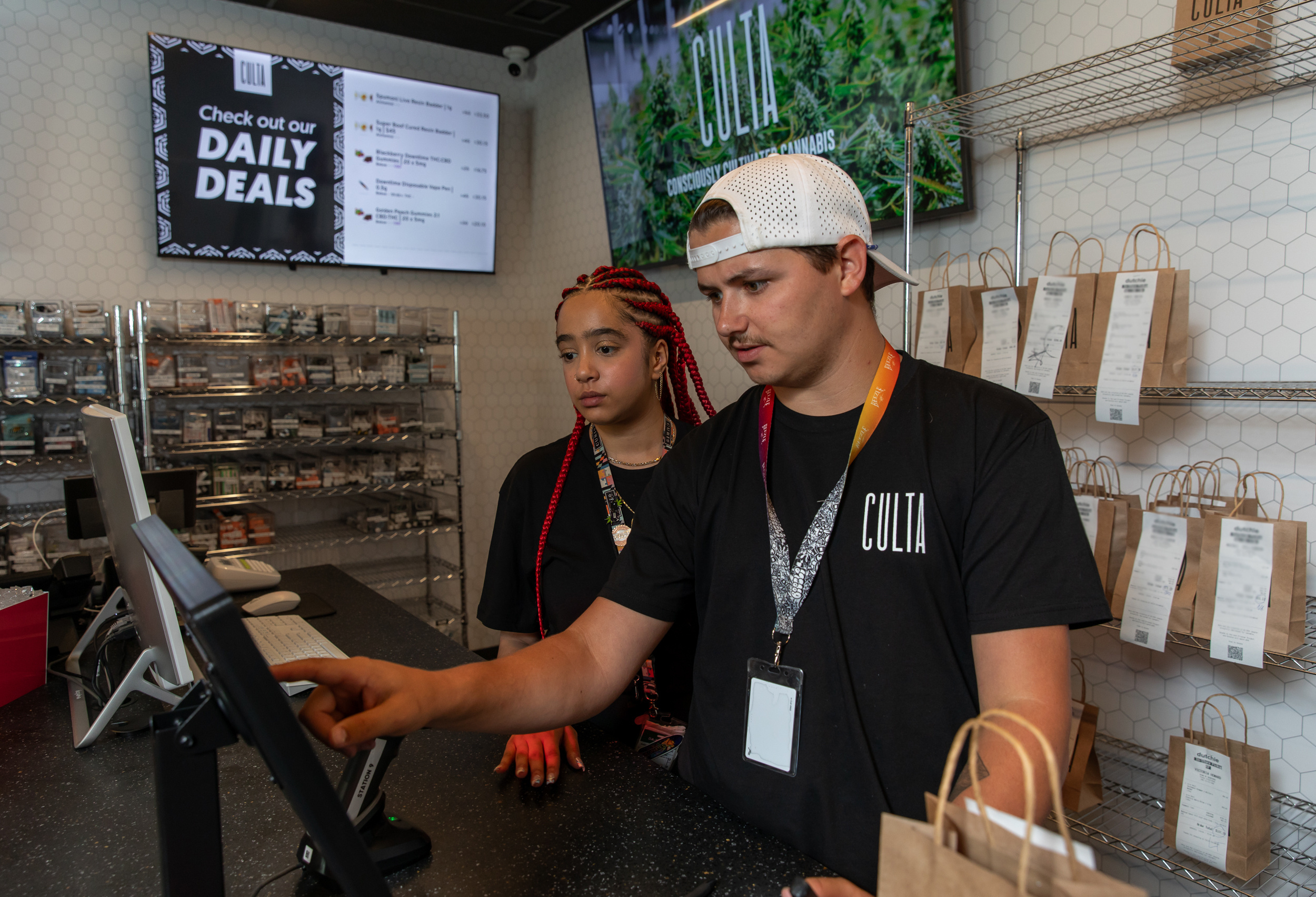 two cannabis dispensary workers behind the counter 